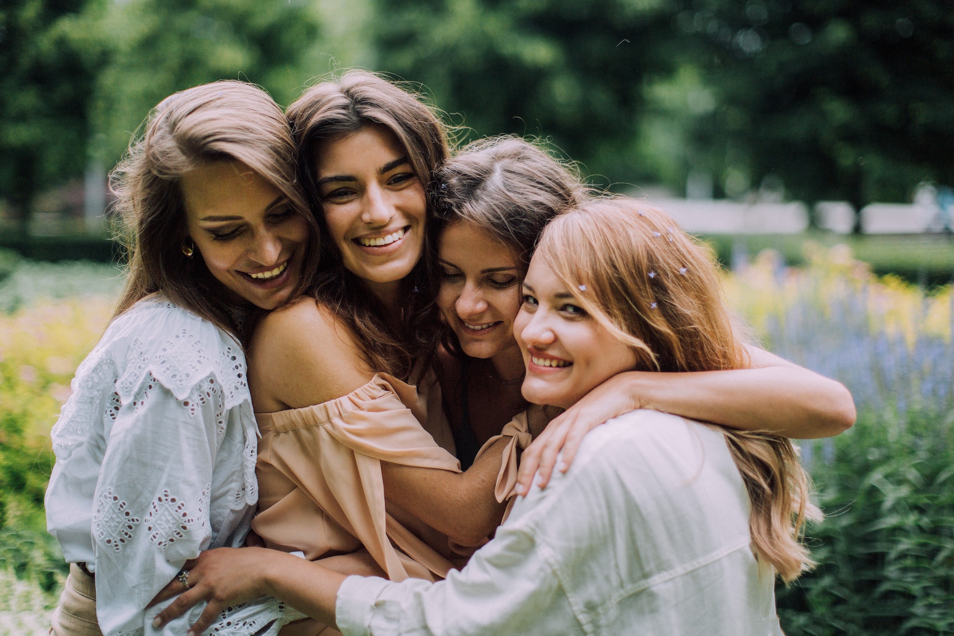 Four women hugging each other and showing confidence in themselves