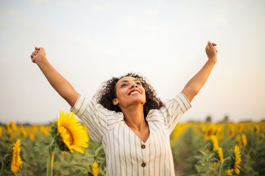 Woman stood in a field celebrating her self-esteem