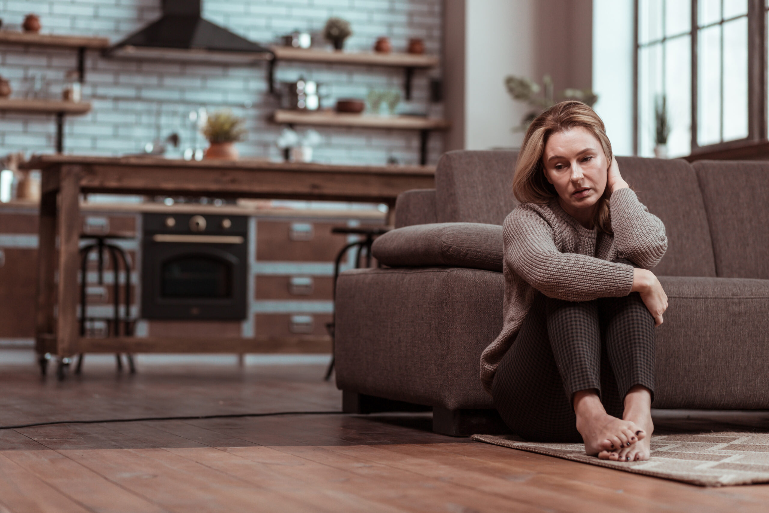 Woman sat on the floor realising the Telltale Signs of Body Image Struggles