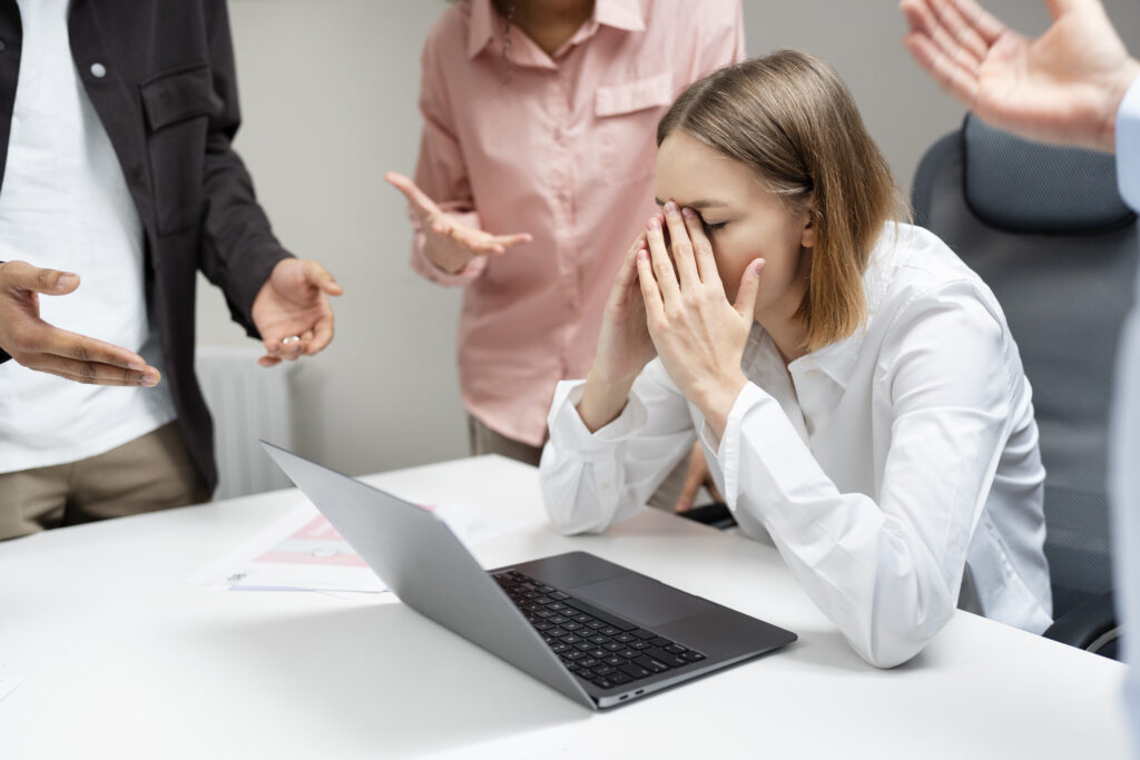 Woman sat in the workplace experiencing negativity due to workplace bullying