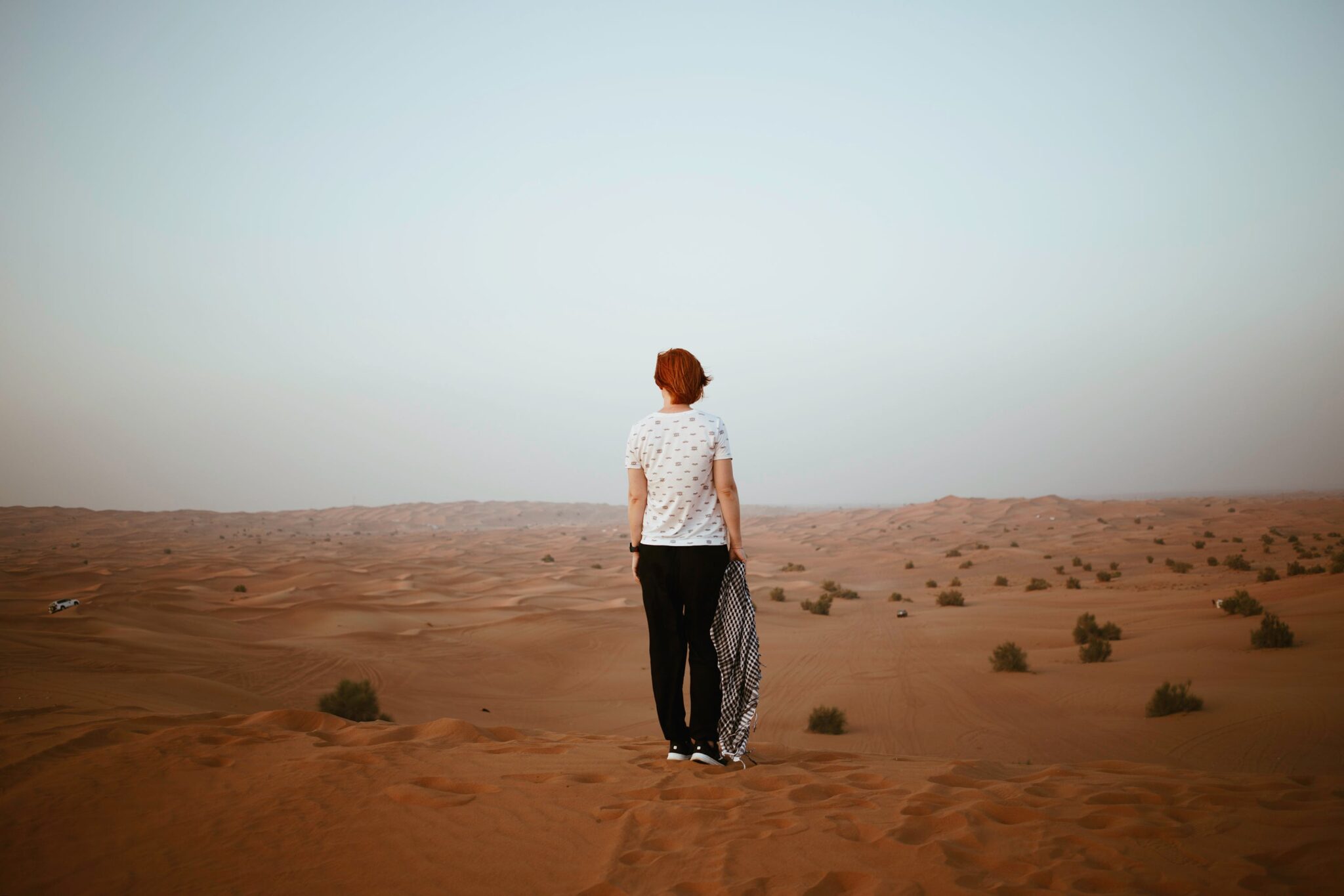 woman stood in desert in white tshirt and jeans feeling lost or looking stranded