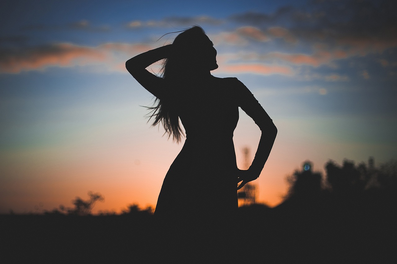woman silhouette against sunset background