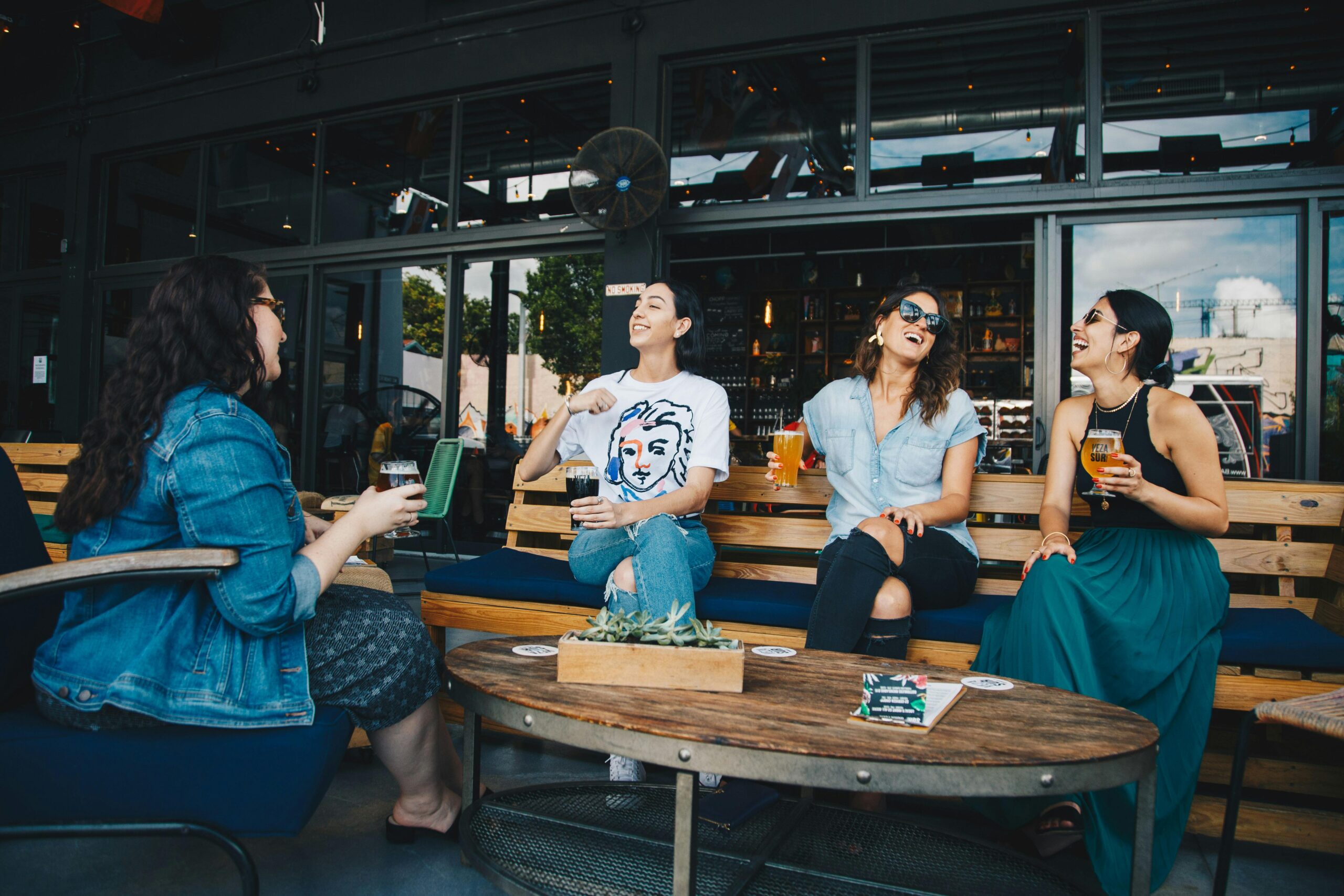 Group of friends laughing outdoors, reflecting on joyful moments that build confidence and happiness.